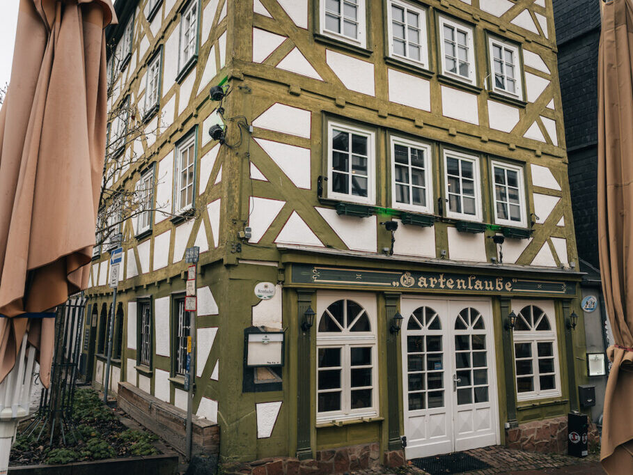 Ein Gebäude mit grün-weißer Fassade und Fenstern.