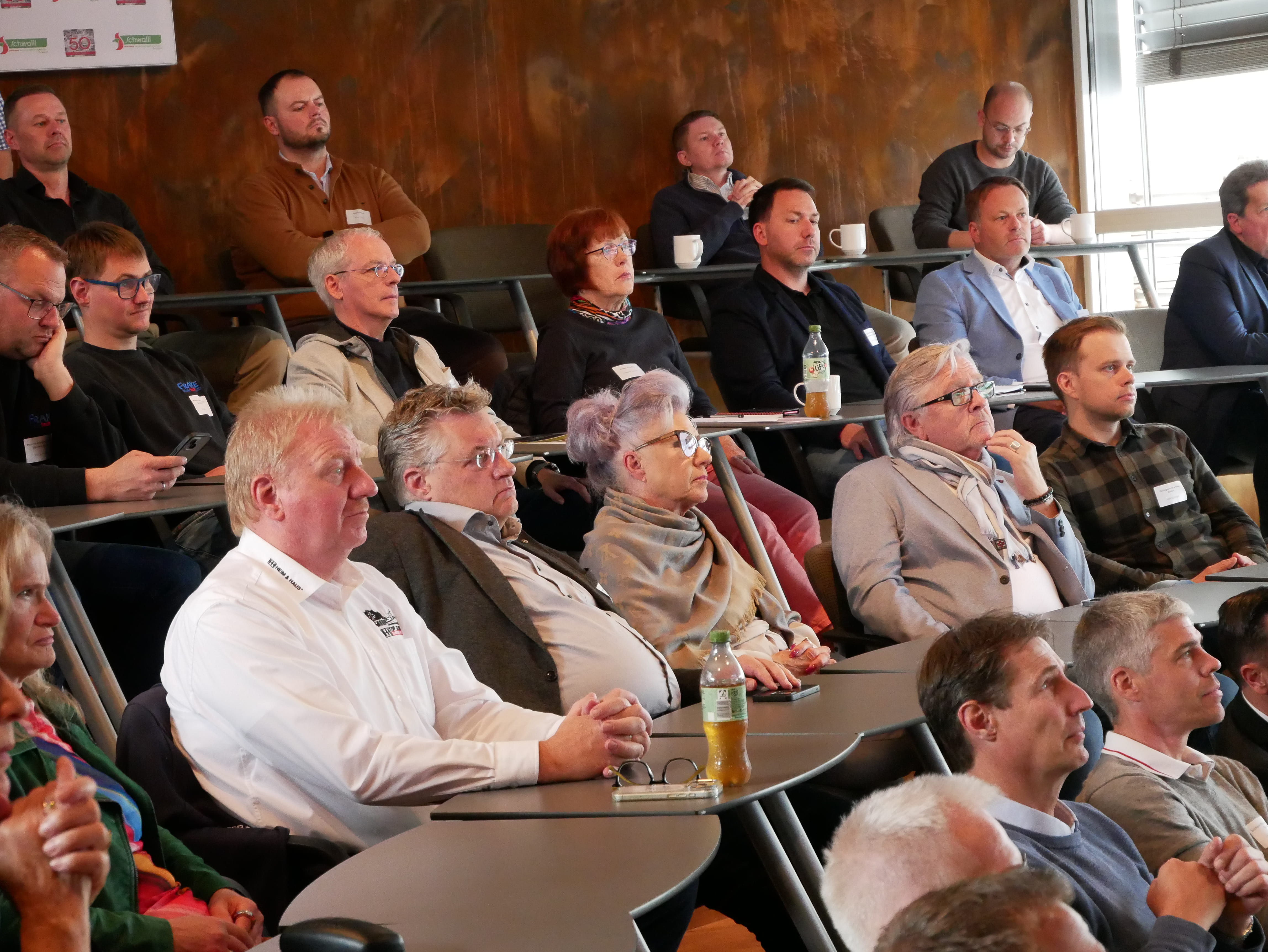 Eine Gruppe von Menschen sitzt auf Stühlen.