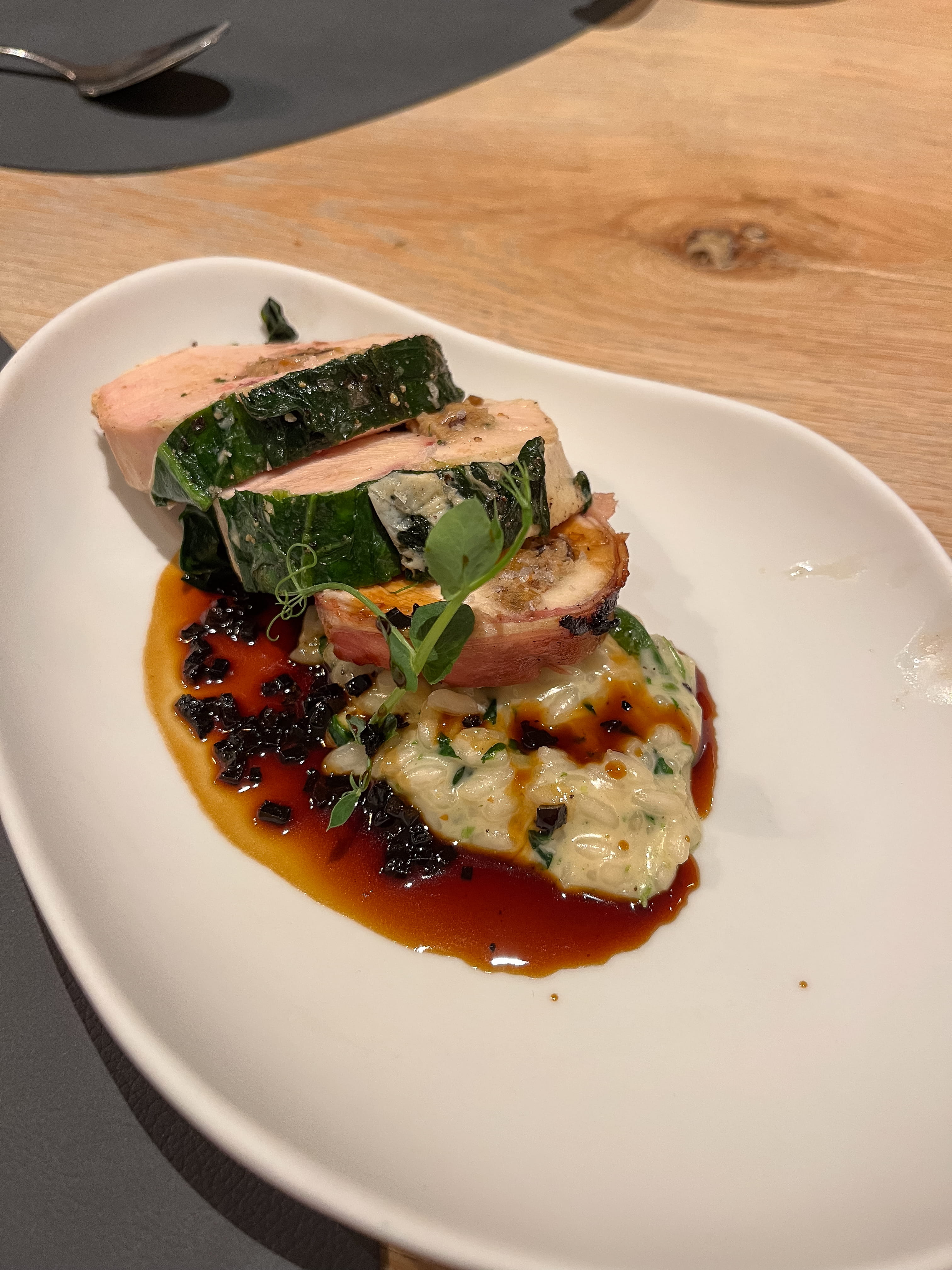 Ein Teller mit kunstvoll angerichteter Speise auf einem Tisch.