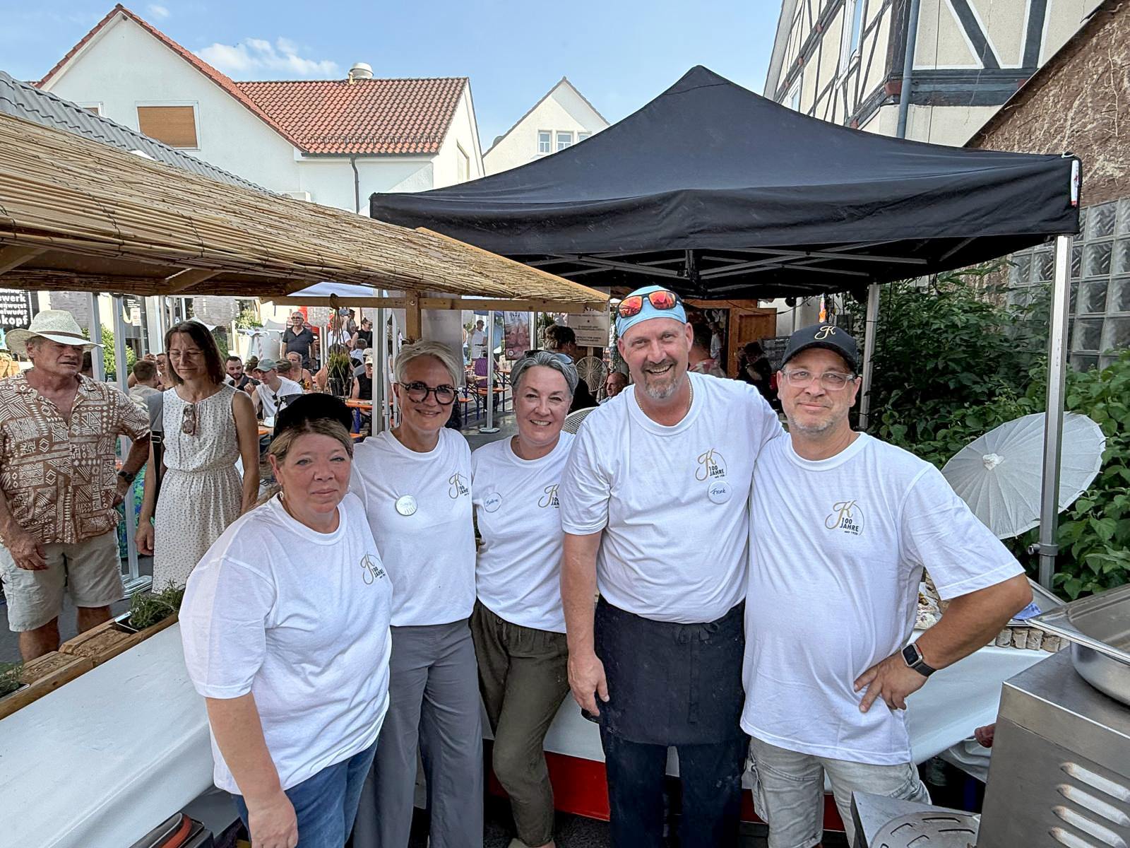 Eine Gruppe von Menschen posiert lächelnd für ein Foto im Freien.