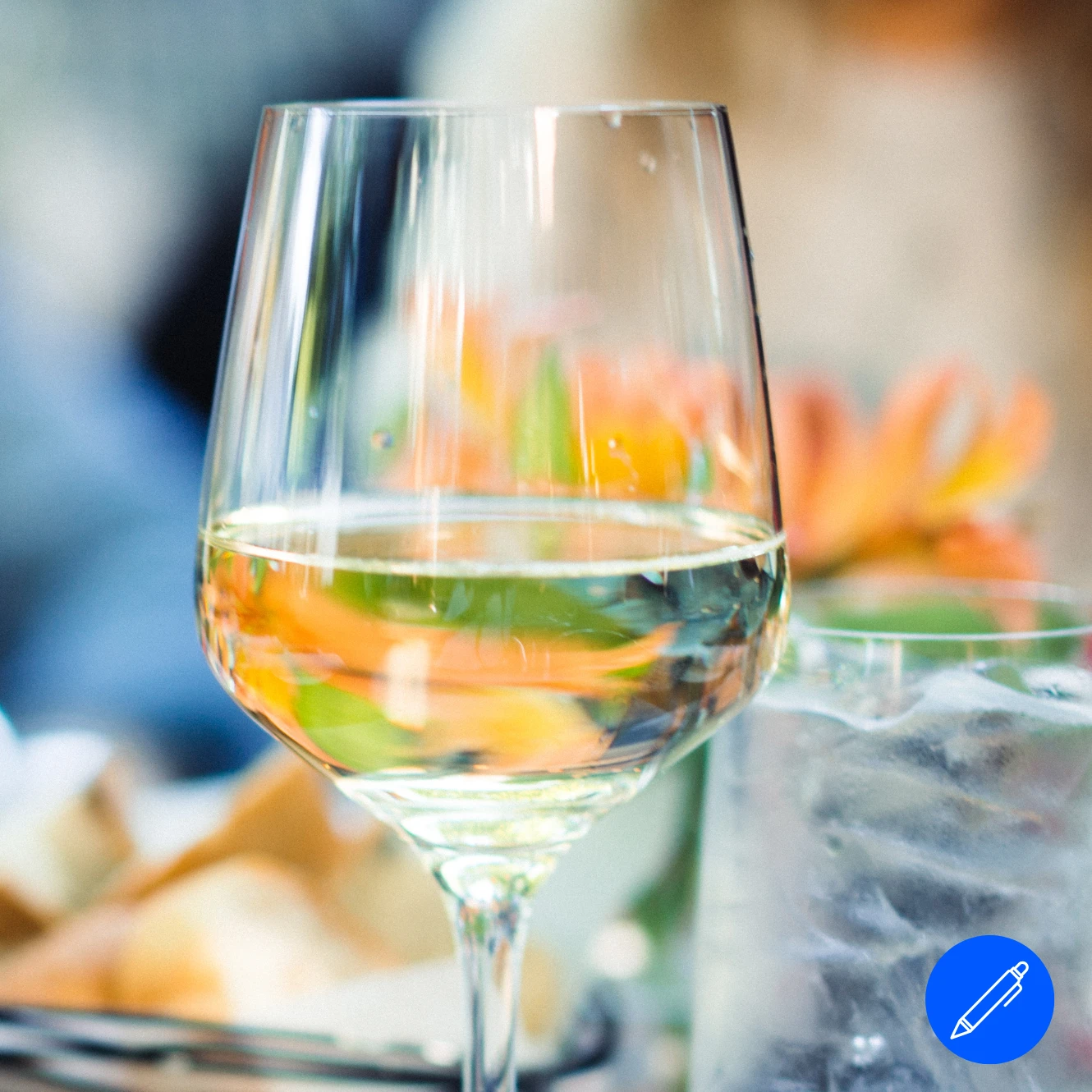 Wein & Dinner Ein Weinglas mit einer Schale Essen im Hintergrund.