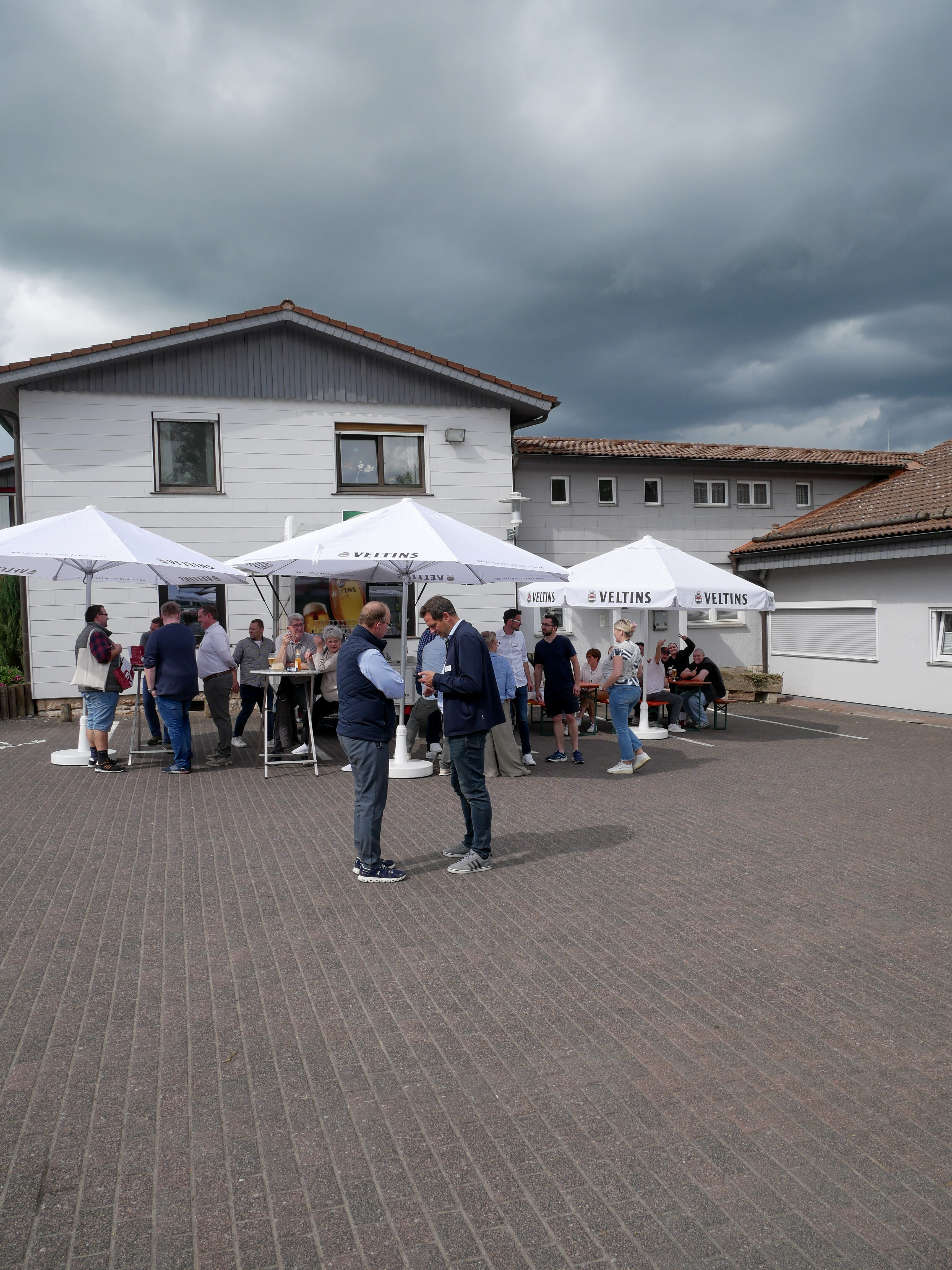 Eine Gruppe von Menschen steht im Freien mit Regenschirmen.