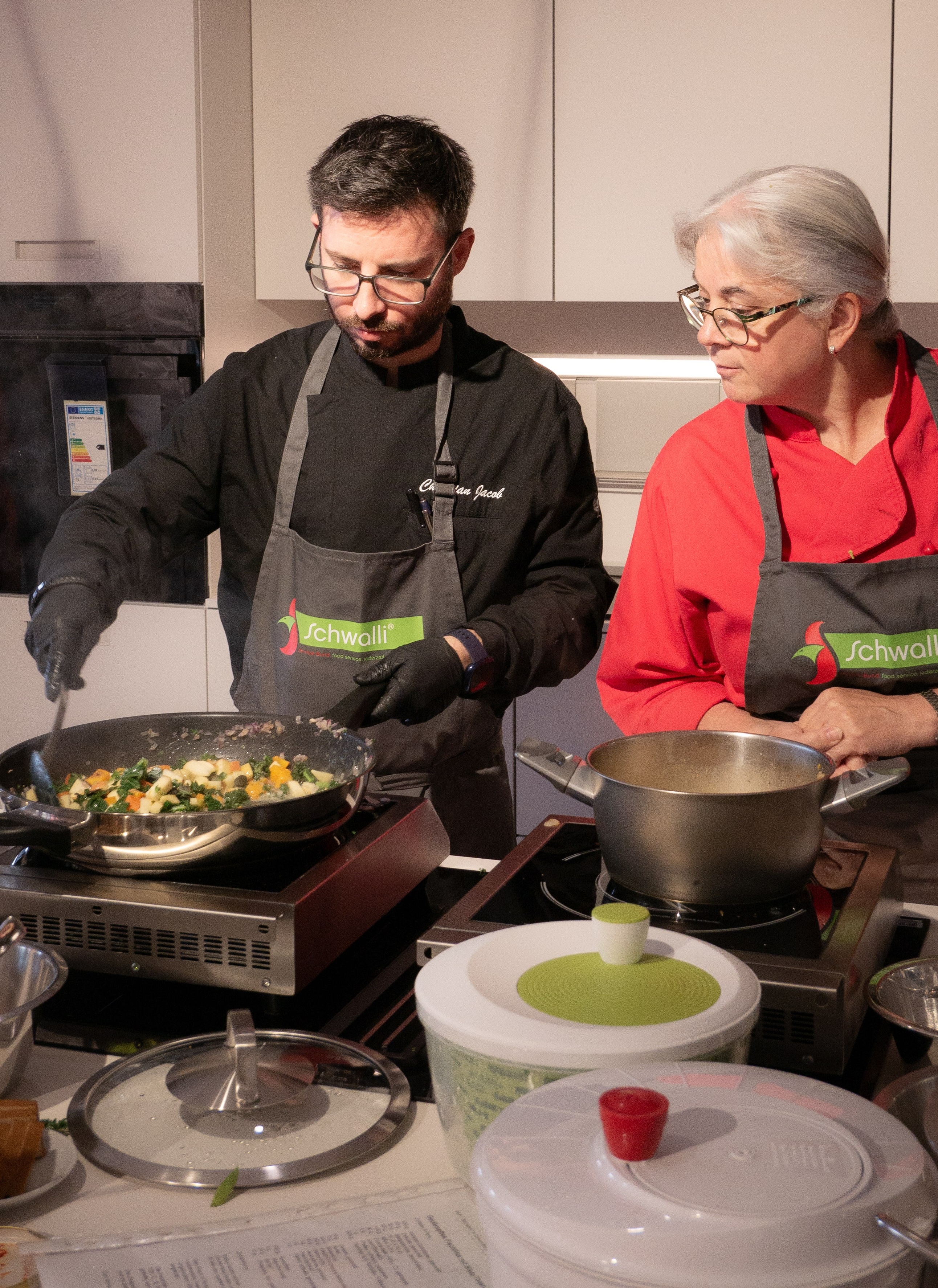 Gesunde Ernährung in der GV Ein Mann und eine Frau kochen in einer Küche.