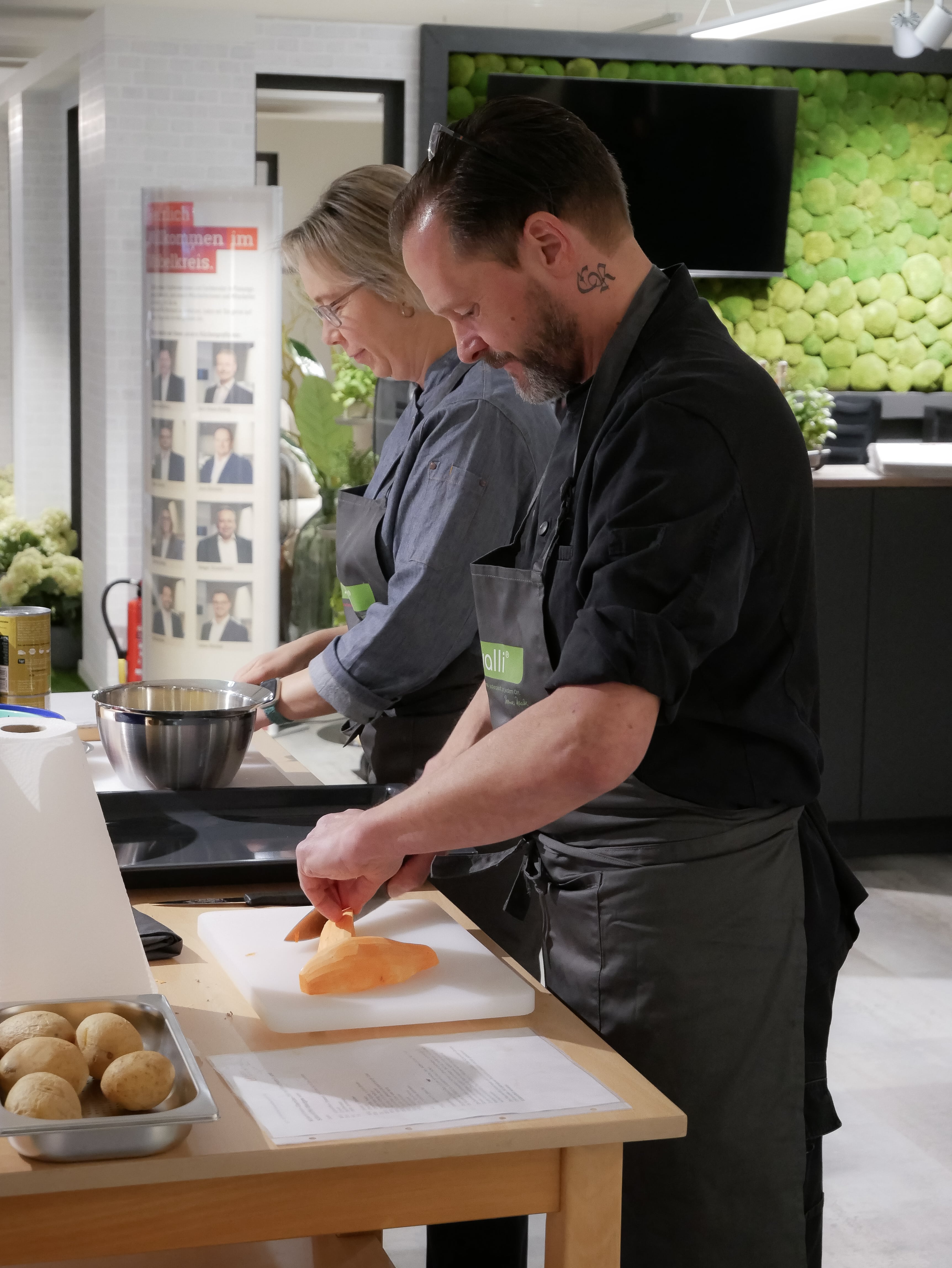 Gesunde Ernährung in der GV Ein Mann und eine Frau in einer Küche beim Kochen.