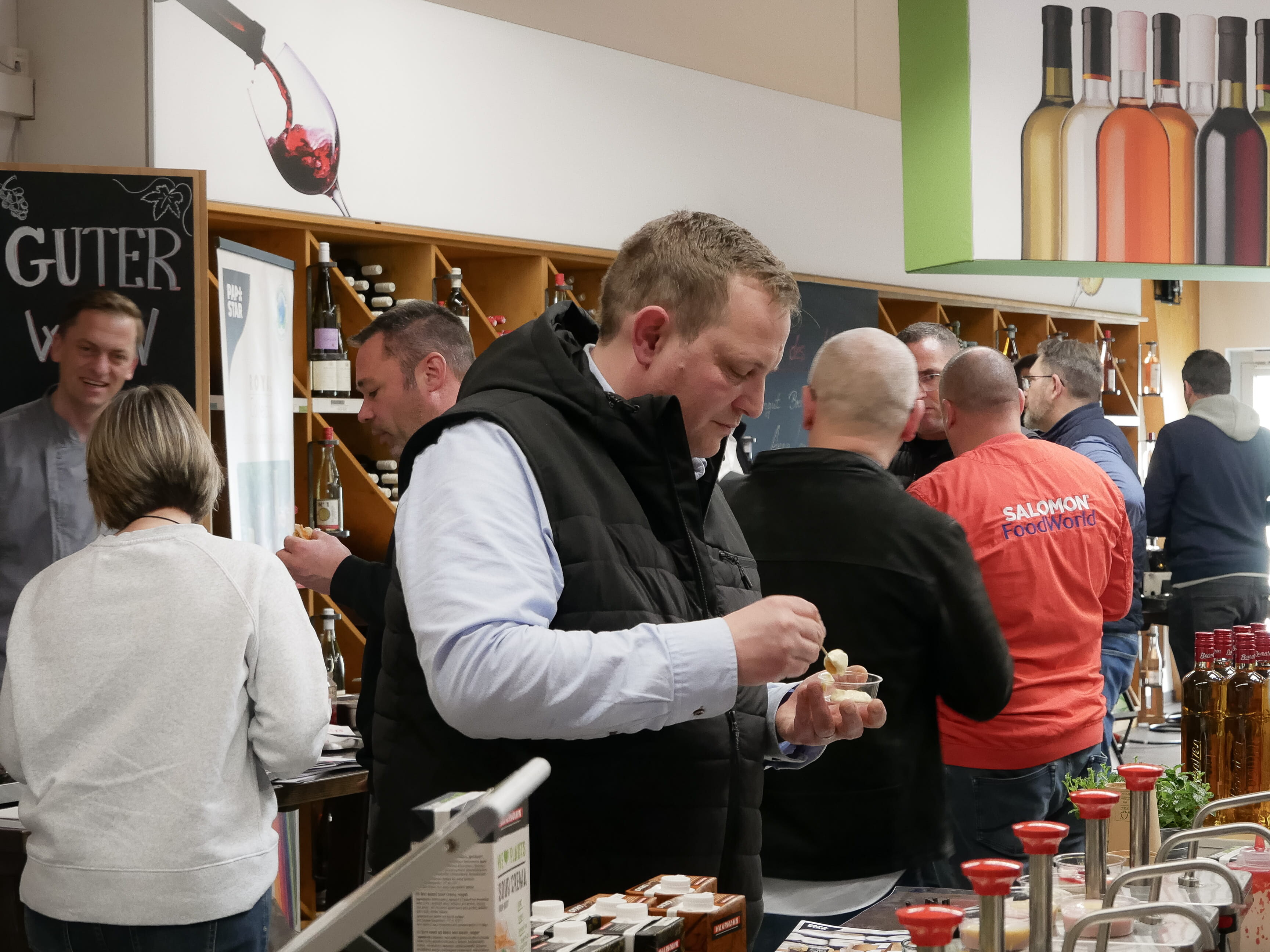 Ein Mann in einer Weste isst Essen.