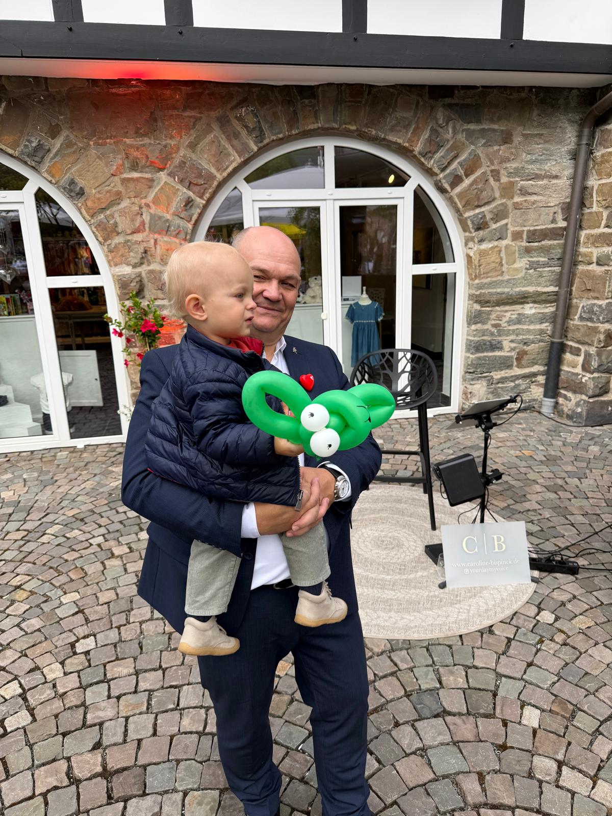 Spitzenküche für Kinderherzen Hotel Deimann Ein Mann hält ein Baby.