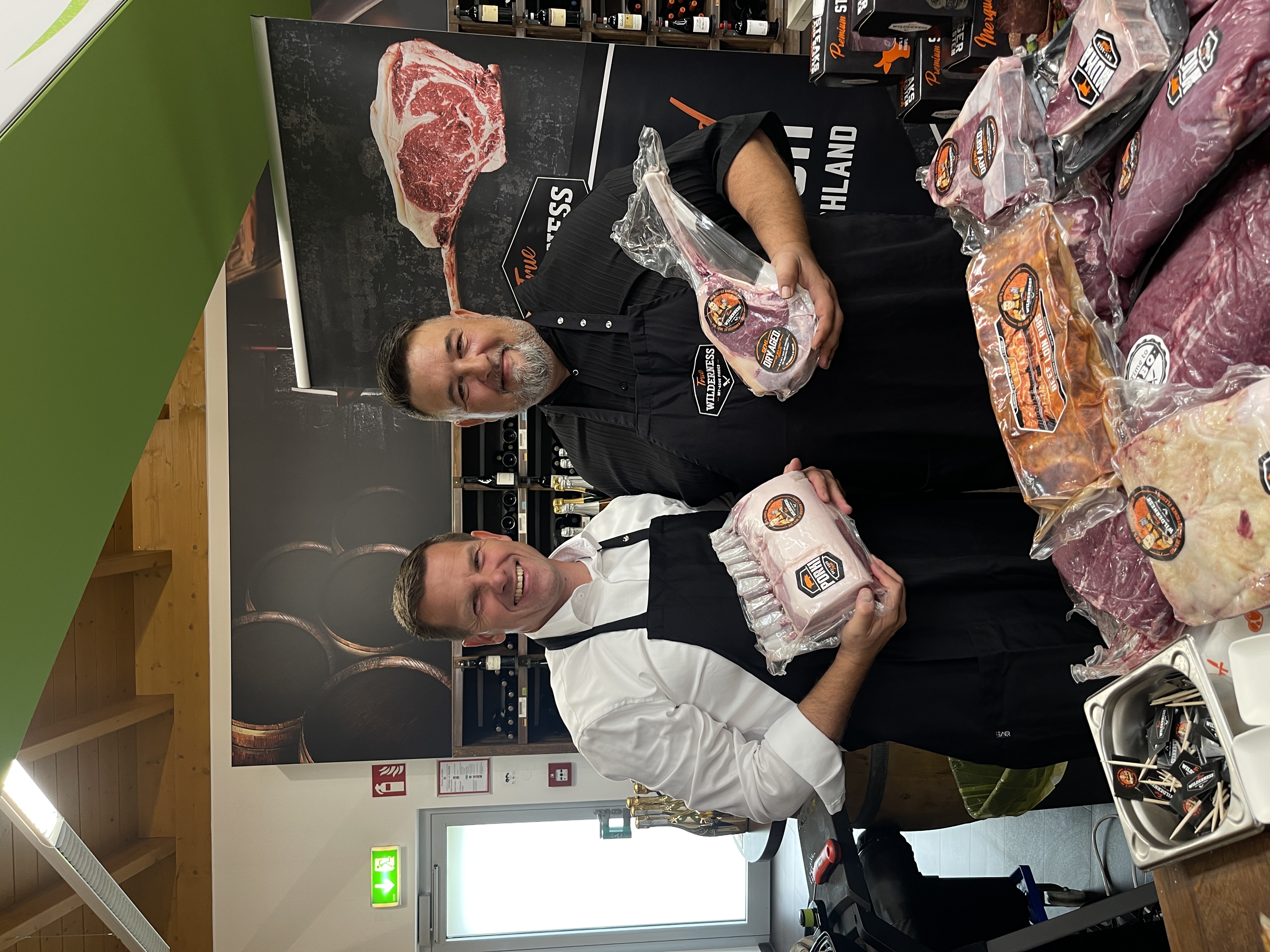 Zwei Männer halten Fleisch in ihren Händen.