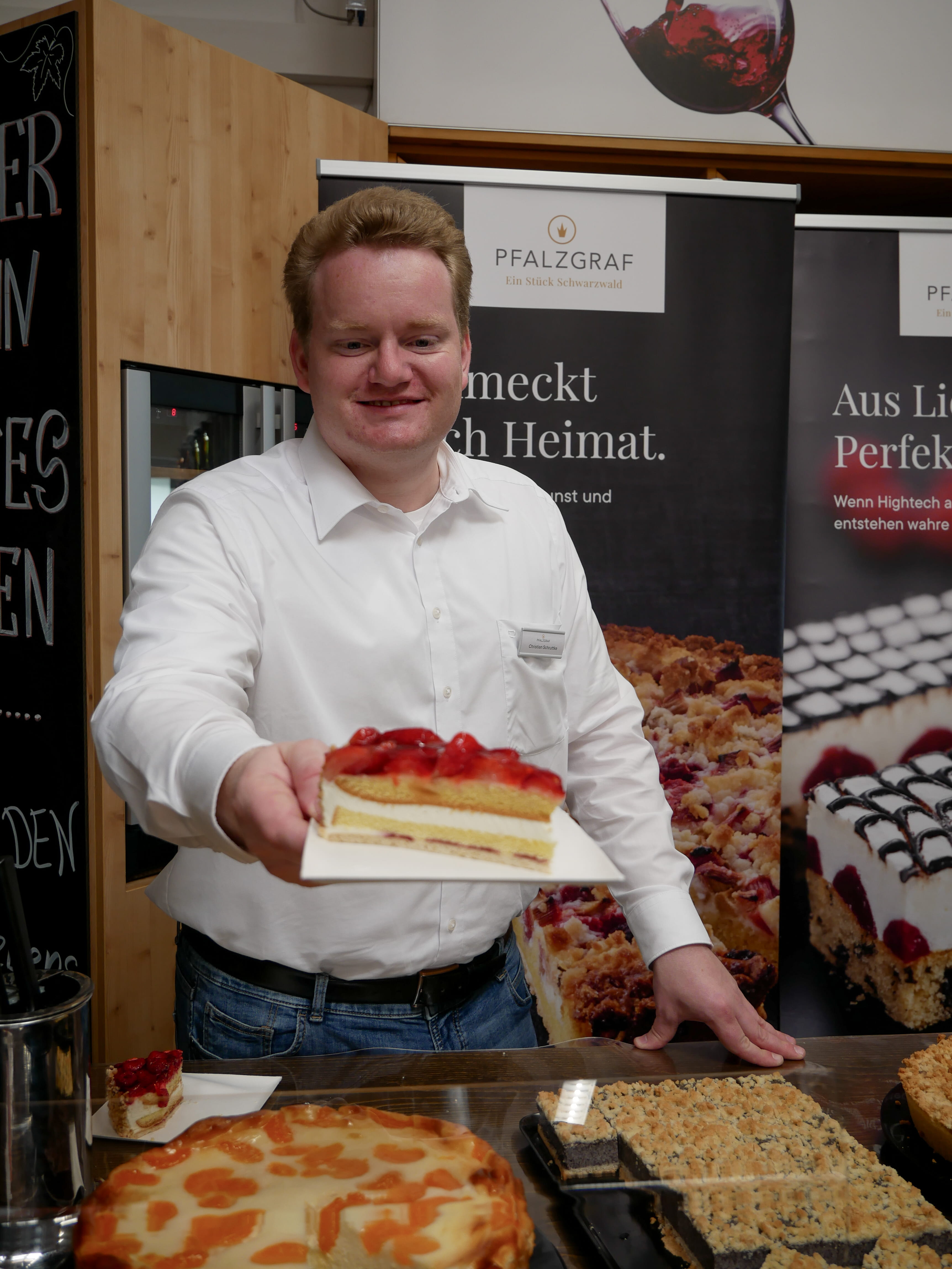 Ein Mann hält ein Stück Kuchen.