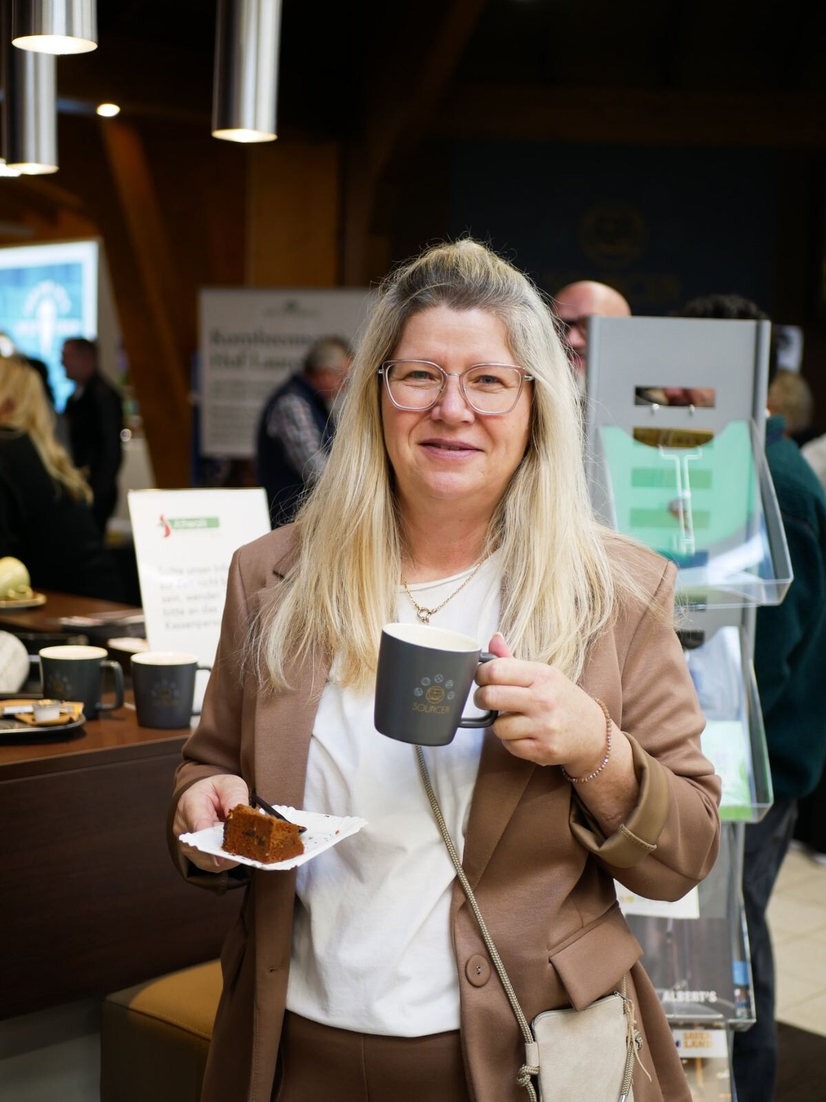 Eine Frau hält einen Teller mit Kuchen und eine Tasse.