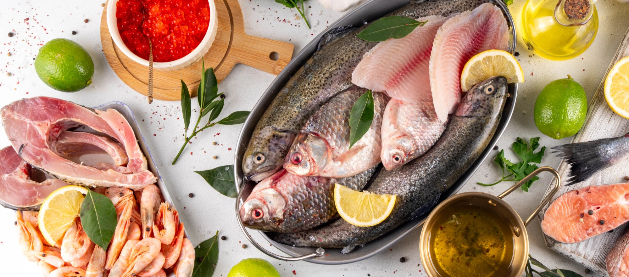 Ein Tablett mit Fisch und Garnelen, garniert mit Zitronen und Kräutern.