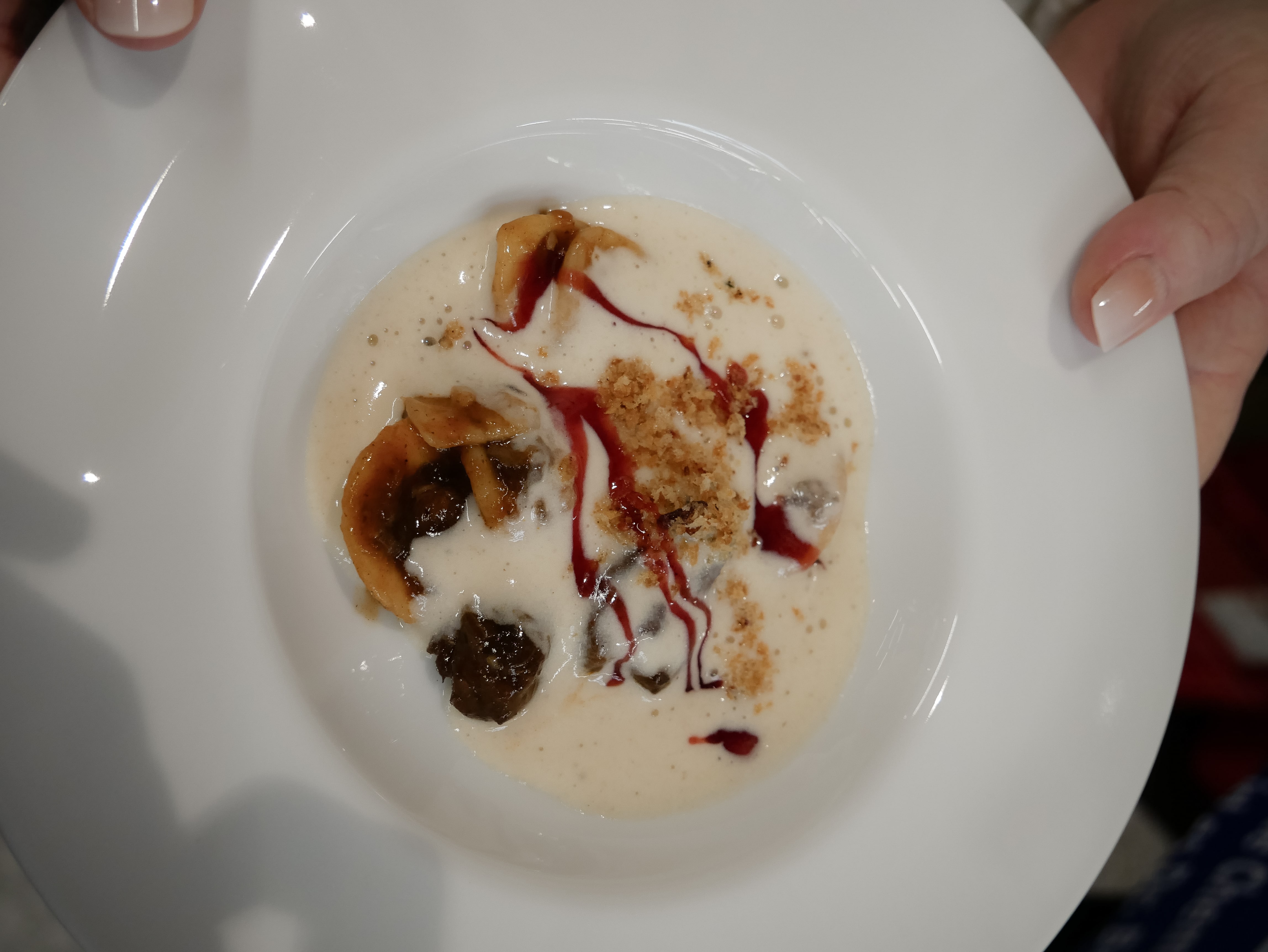 Ein Teller mit Speisen und einer Hand.