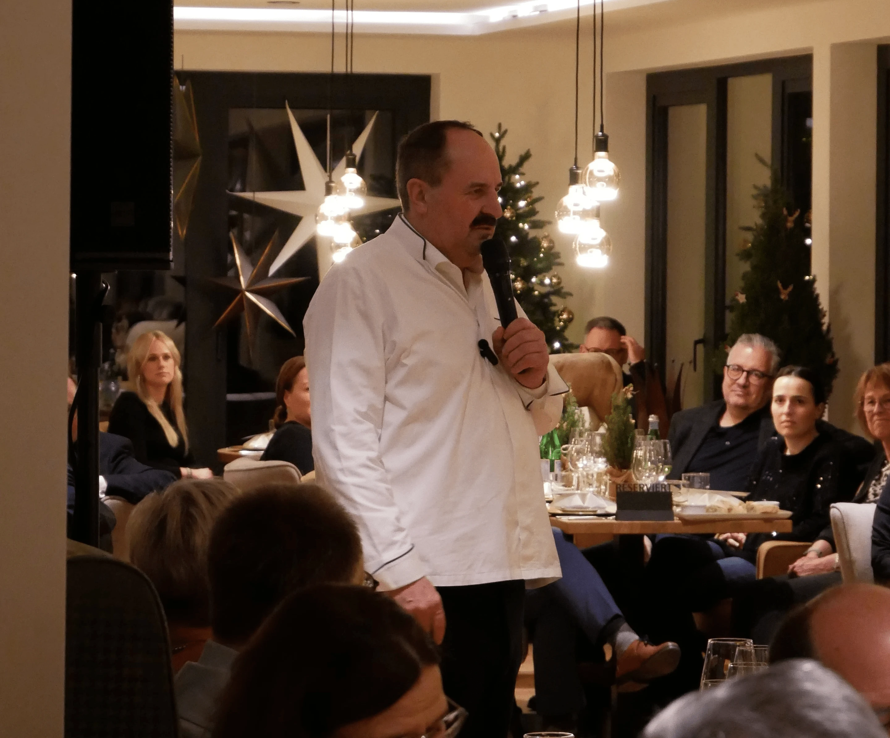 Ein Mann steht vor einer Gruppe von Menschen.