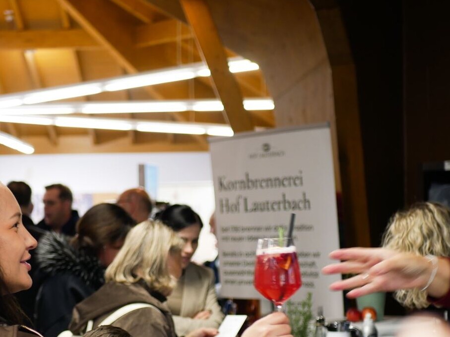 Schwalli kocht über 2026 Eine Gruppe von Menschen steht in einem Raum, einige tragen Anzüge.