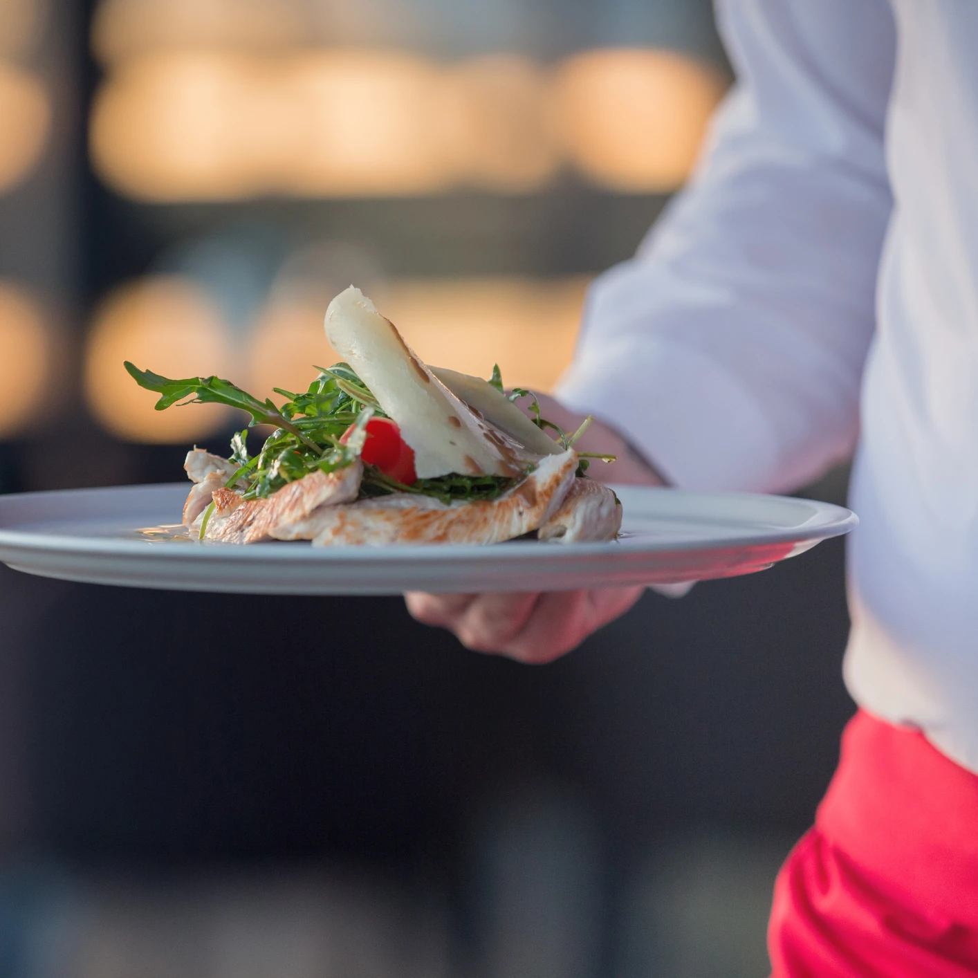 Eine Person hält einen Teller mit Fast Food und Meeresfrüchten.
