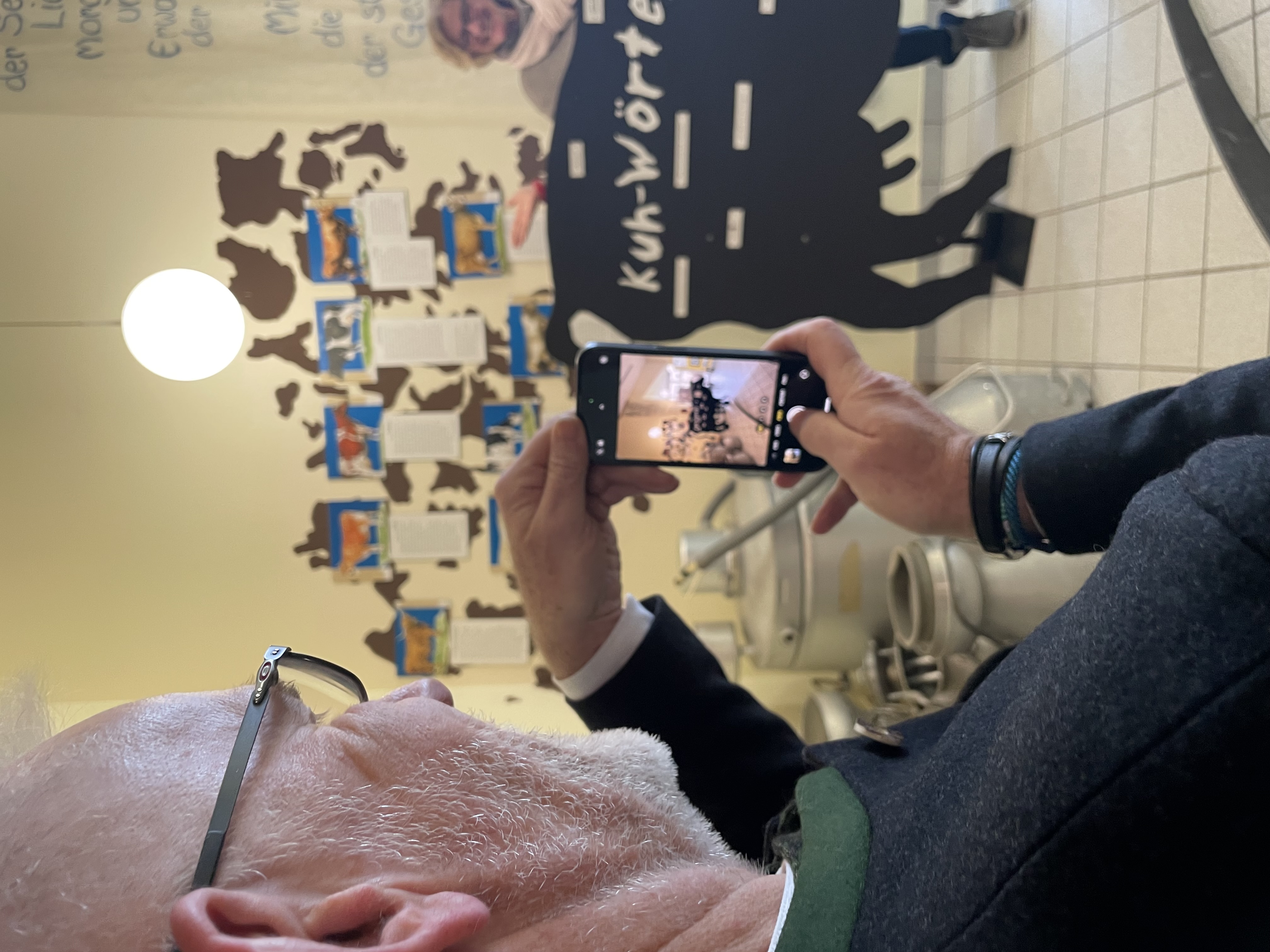 Upländer Bauernmolkerei Ein Mann fotografiert eine Kuh.