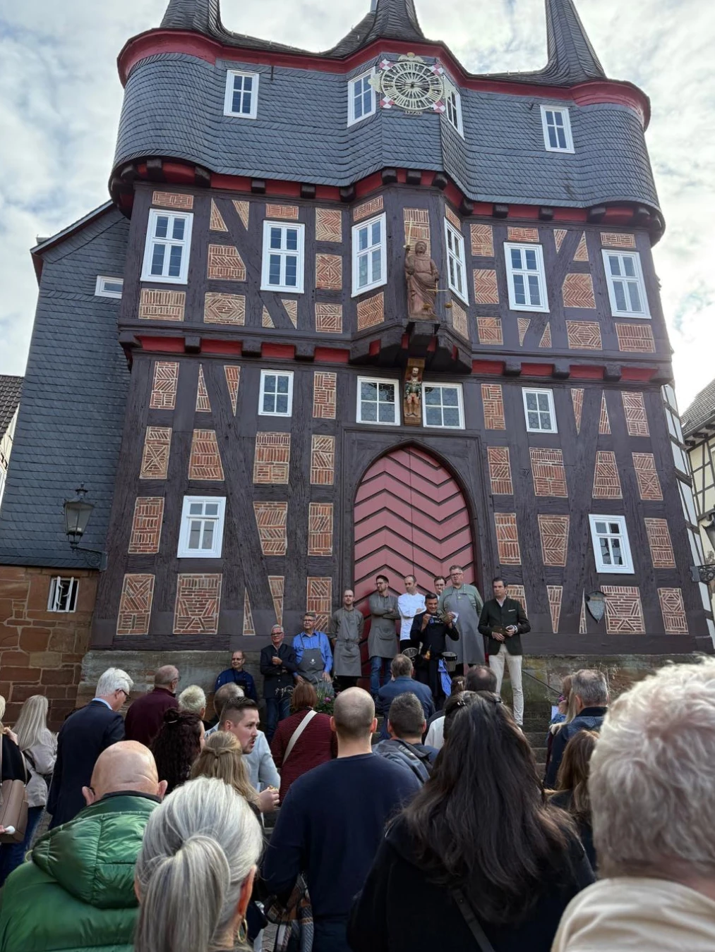 Begrüßung vor dem Rathaus Eine Gruppe von Menschen steht vor einem Gebäude.