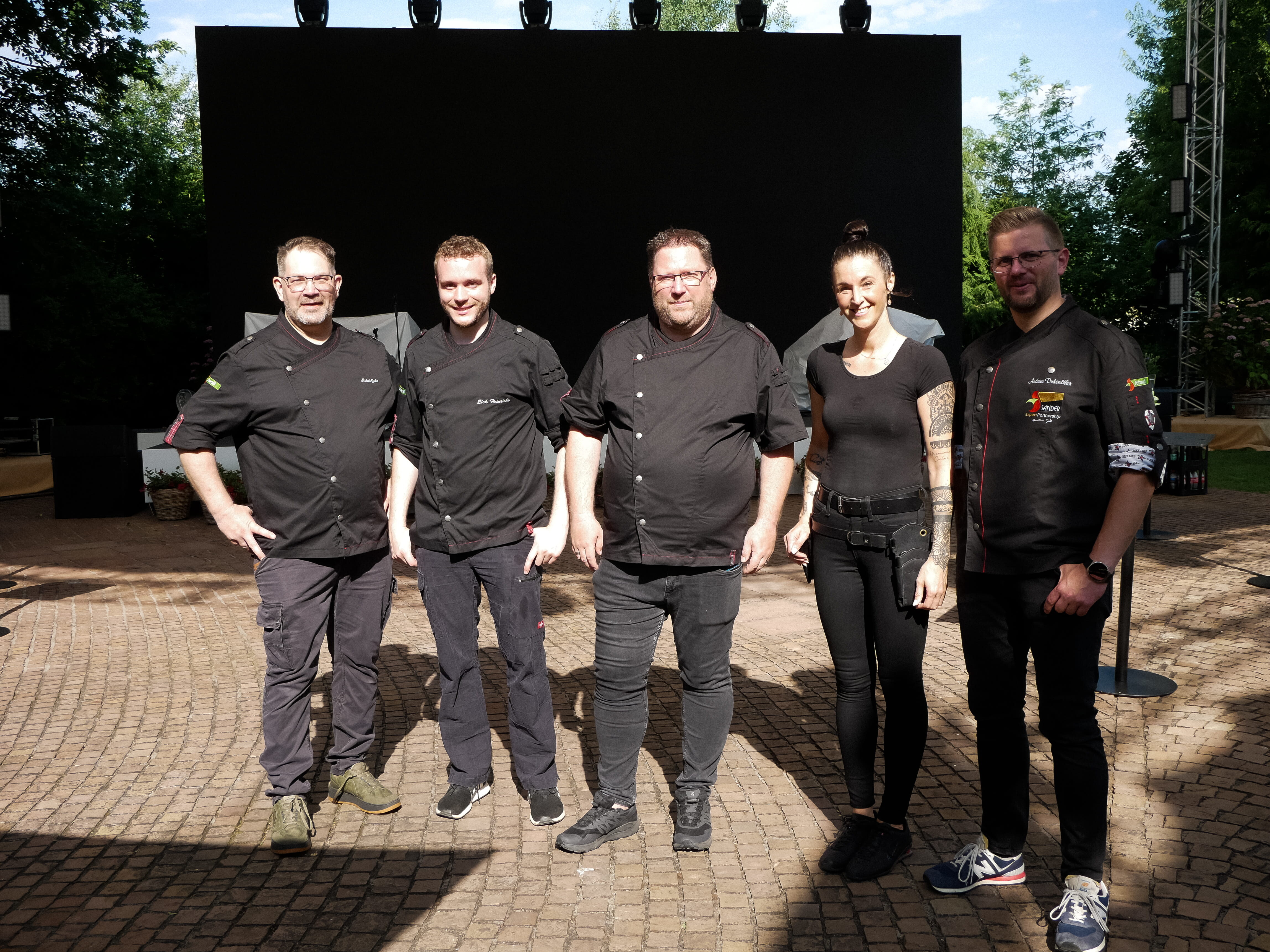 Eine Gruppe von Menschen posiert für ein Foto im Freien.
