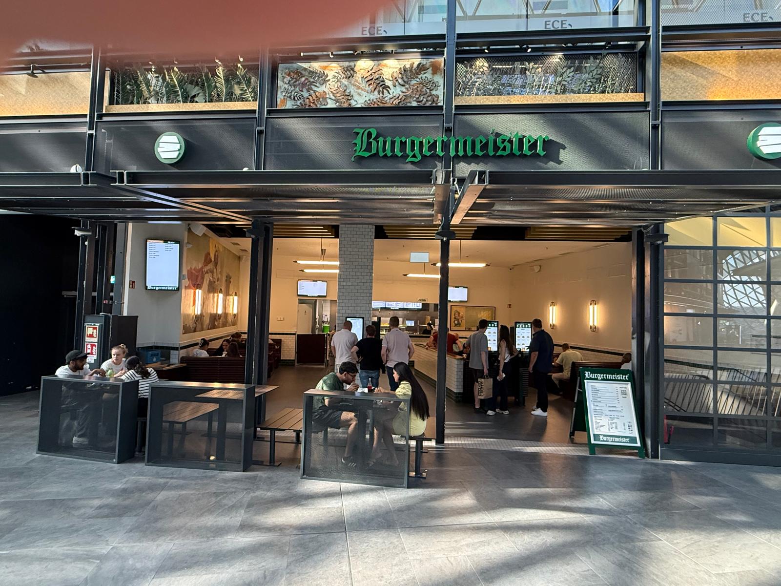 Eine Gruppe von Menschen steht lächelnd vor einem Gebäude.
