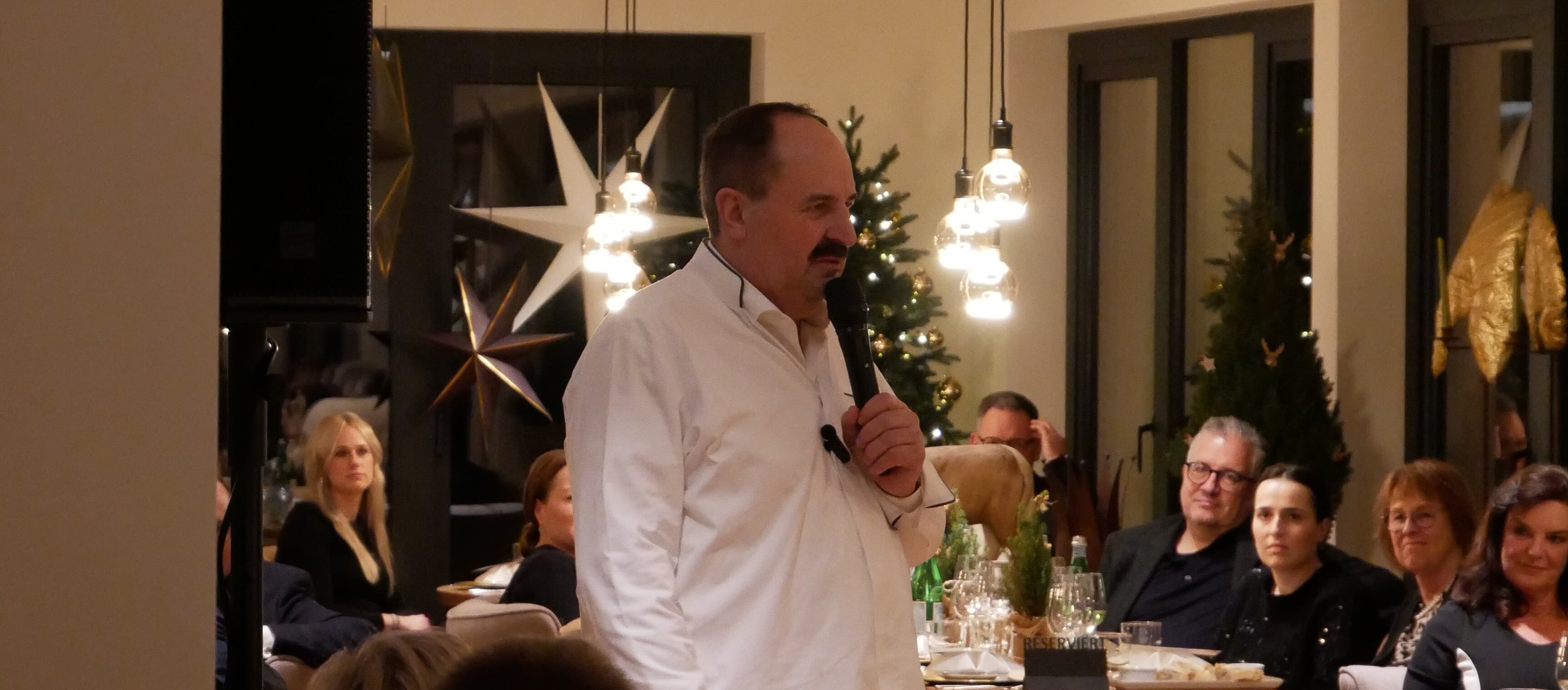 Ein Mann steht vor einer Gruppe von Menschen.