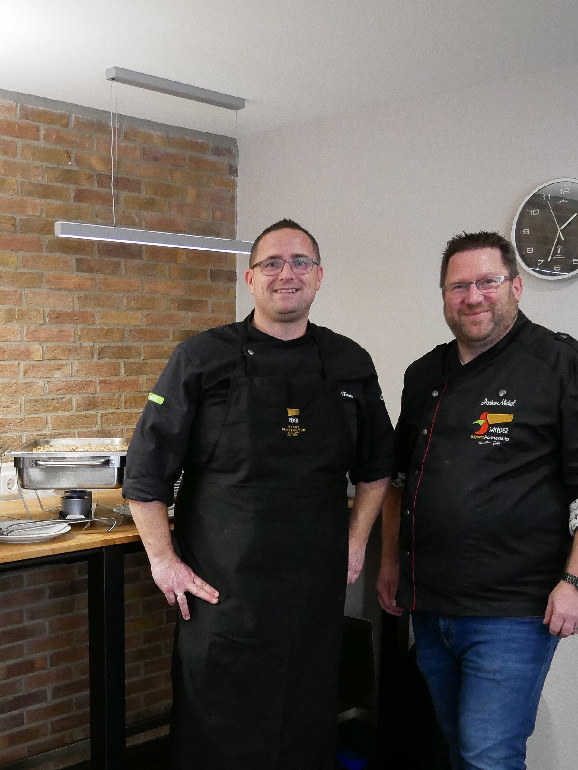 Erfolgsrezepte für Morgen Zwei Männer stehen in einer Küche.