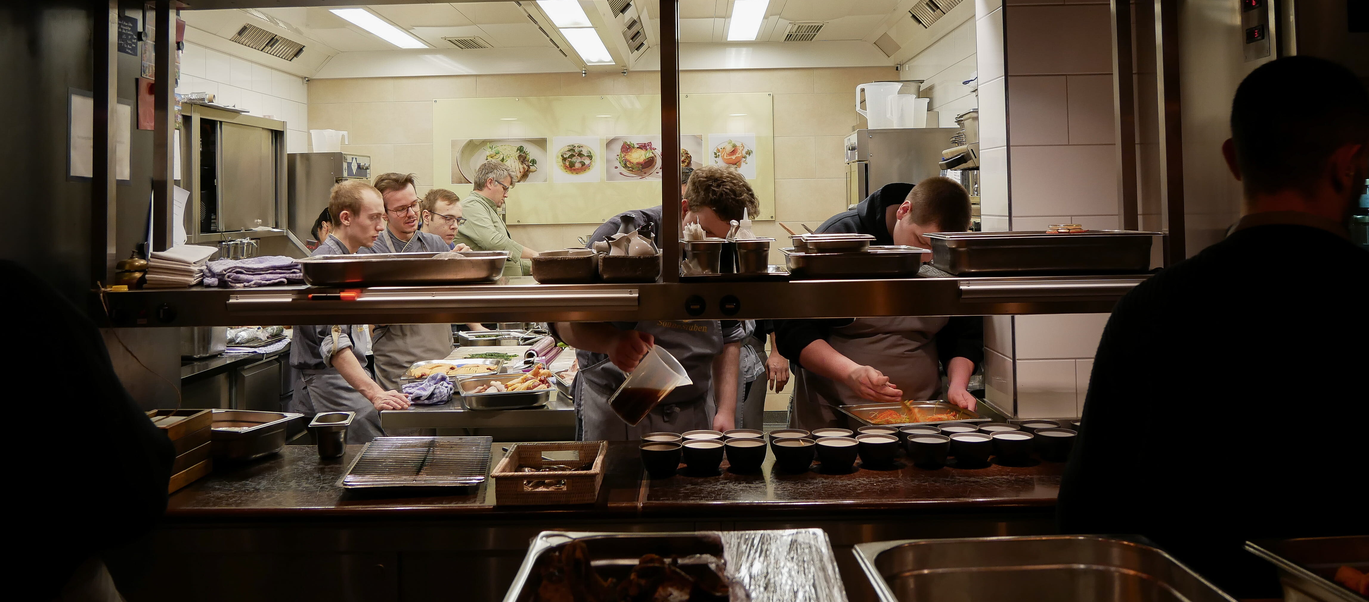 Eine Gruppe von Menschen kocht in einer Küche.