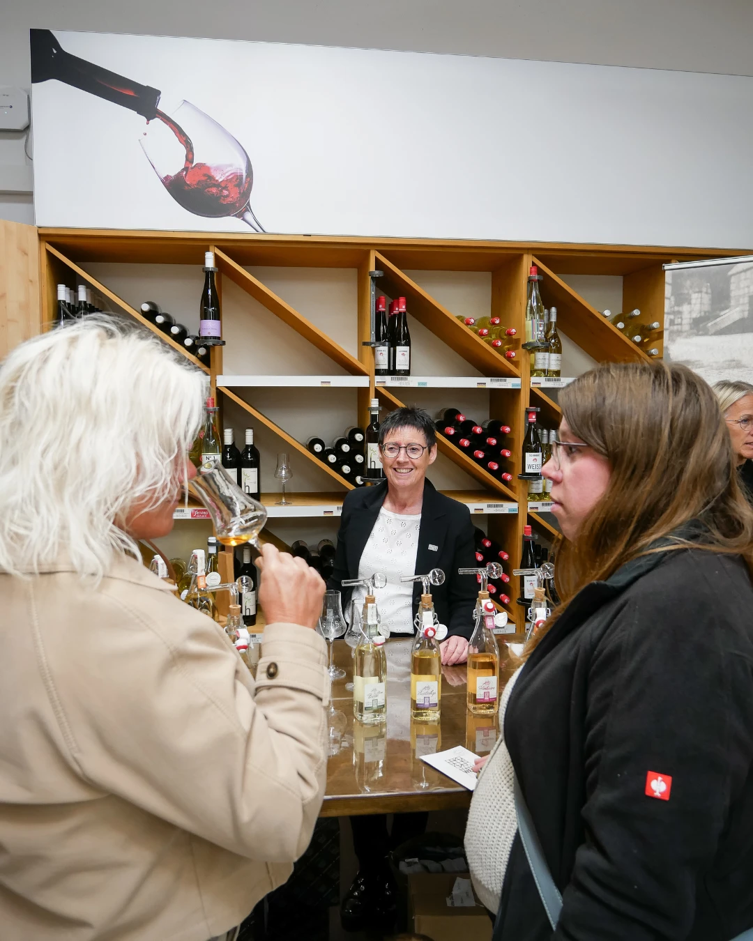 Eine Gruppe von Menschen trinkt Wein.