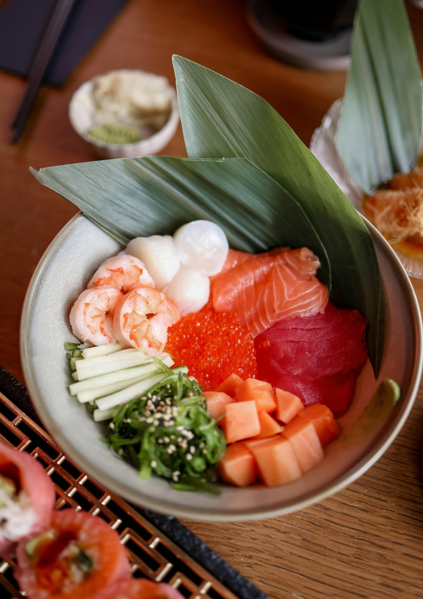 Schale mit Sashimi, garniert mit einem Blatt.