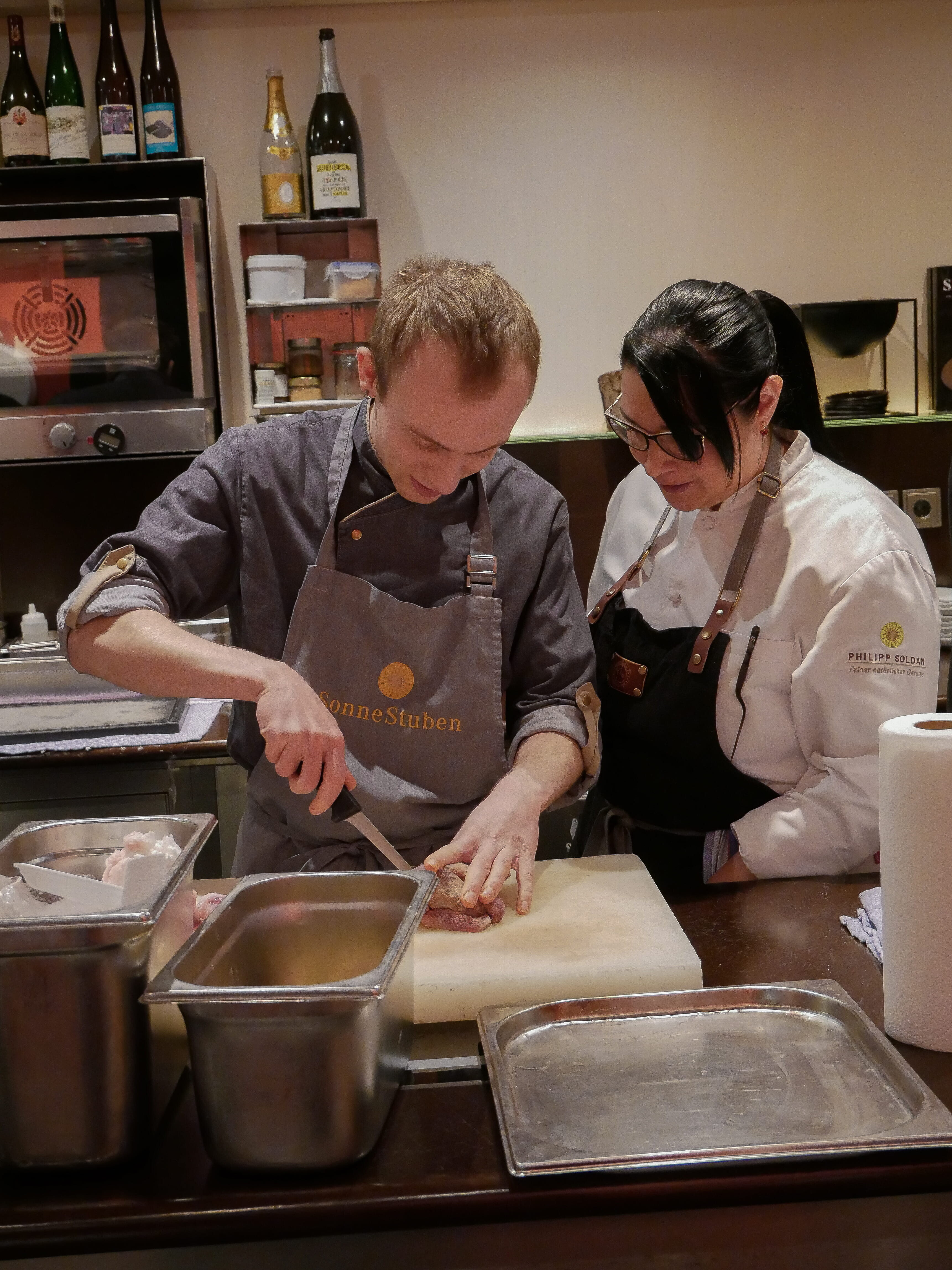 Ein Mann und eine Frau in einer Küche beim Kochen.