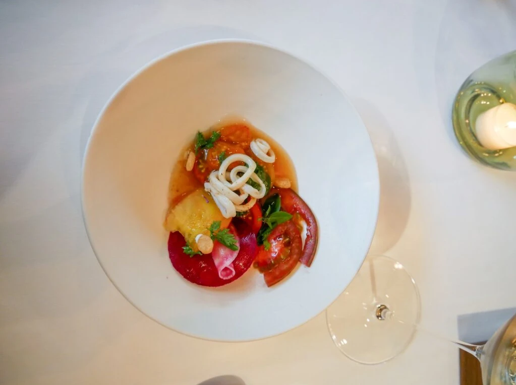 Ein Teller mit kunstvoll angerichtetem Essen auf einem Tisch.