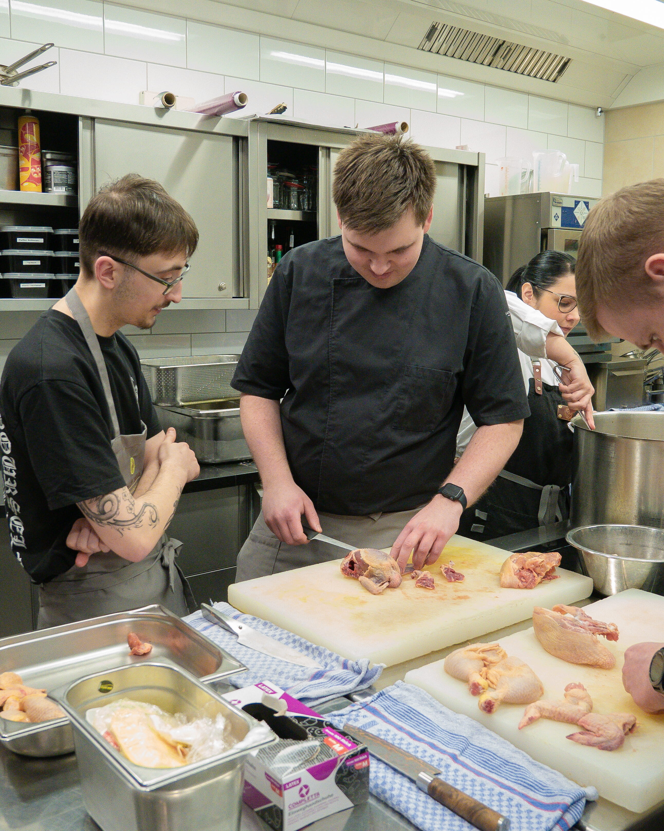 Eine Gruppe von Menschen in einer Küche beim Zubereiten von Speisen.