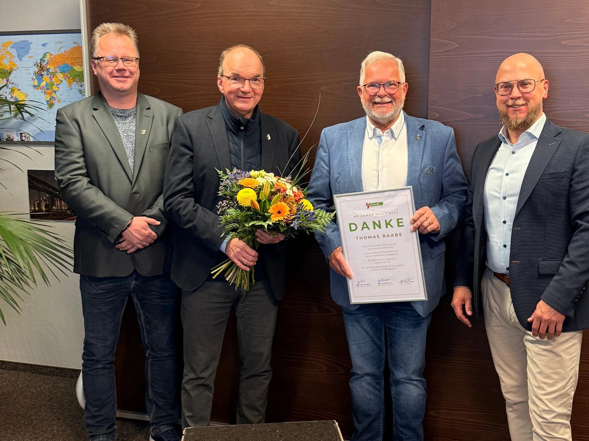 Thomas Raabe Eine Gruppe von Männern in Anzügen lächelt und posiert für ein Foto.