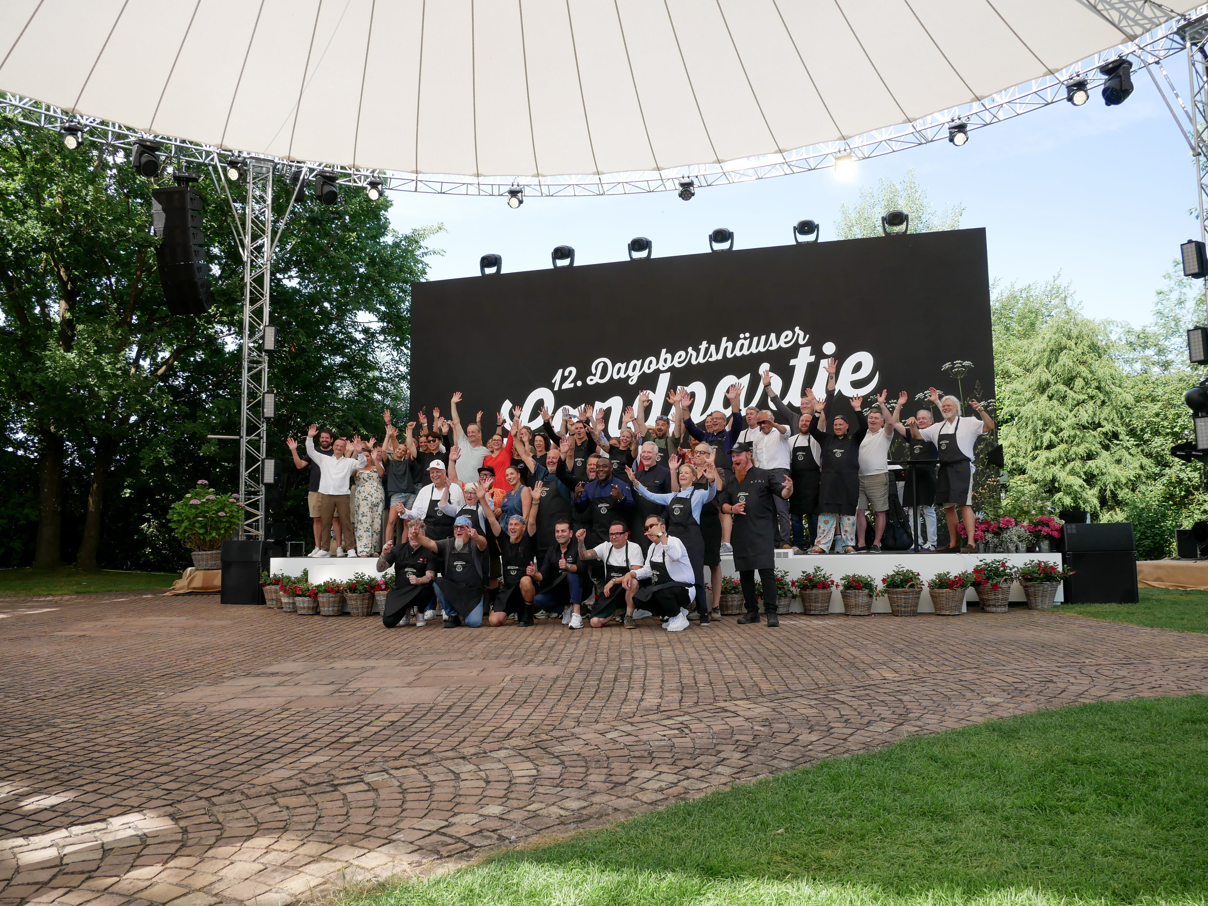 Eine Gruppe von Menschen posiert für ein Foto im Freien.