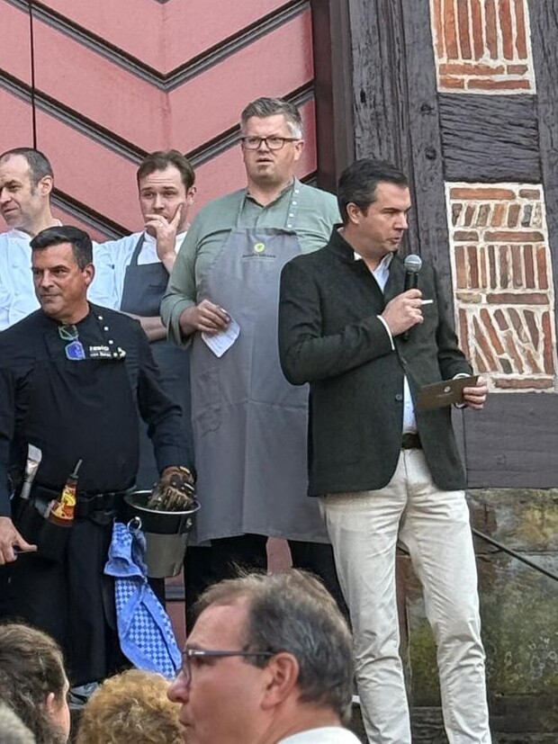 Erik Arnecke Eine Gruppe von Menschen steht vor einem Gebäude.