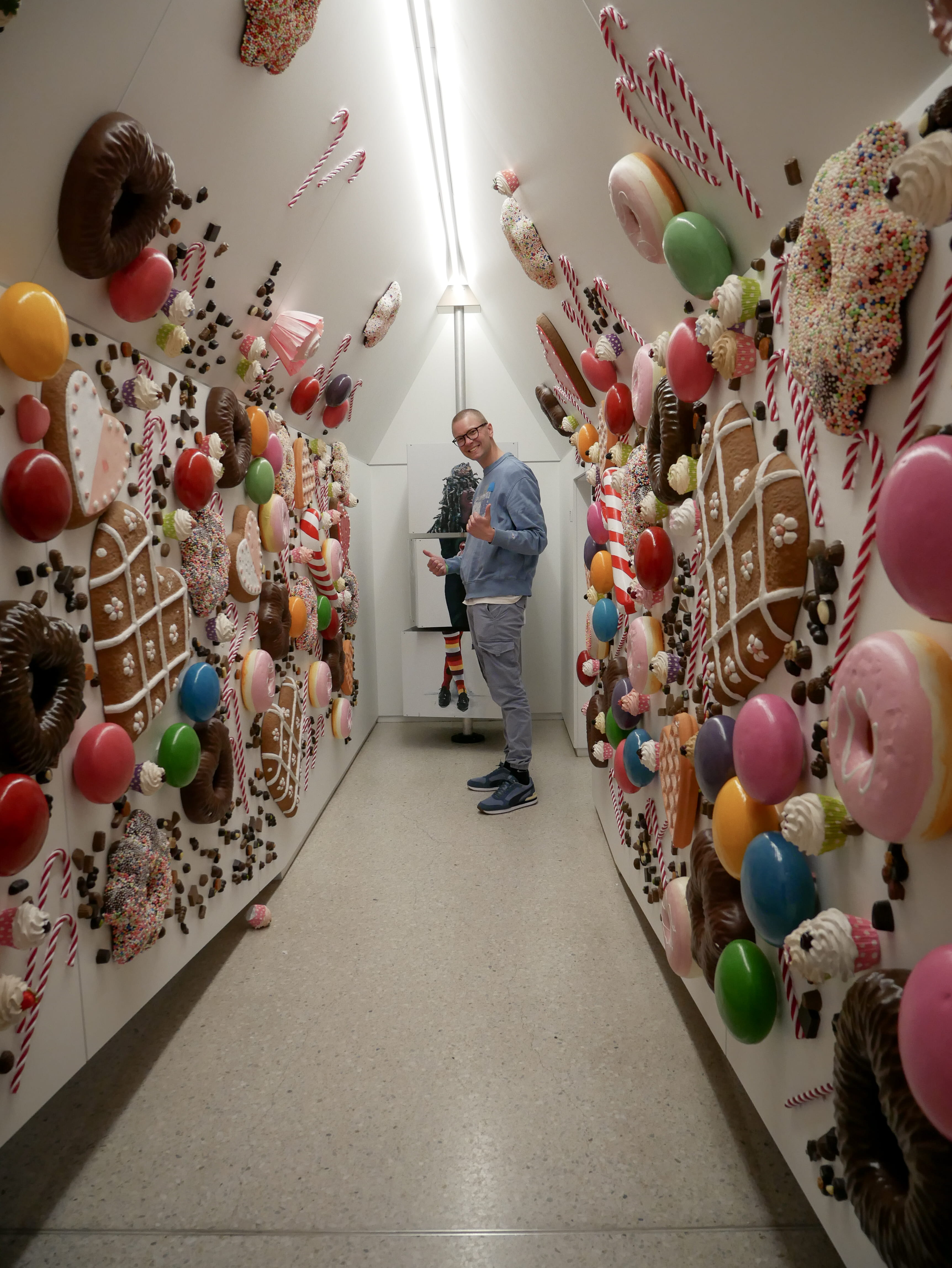 Workshop "Überraschung - Kassel" Ein Mann steht in einem Flur mit vielen verschiedenen Arten von Donuts.