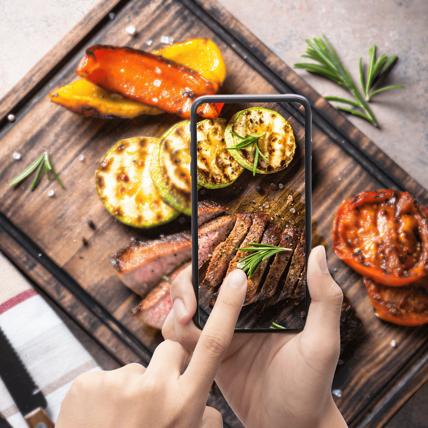 Workshopkalender 2026 Hände halten ein Handy mit einem Foto von Essen