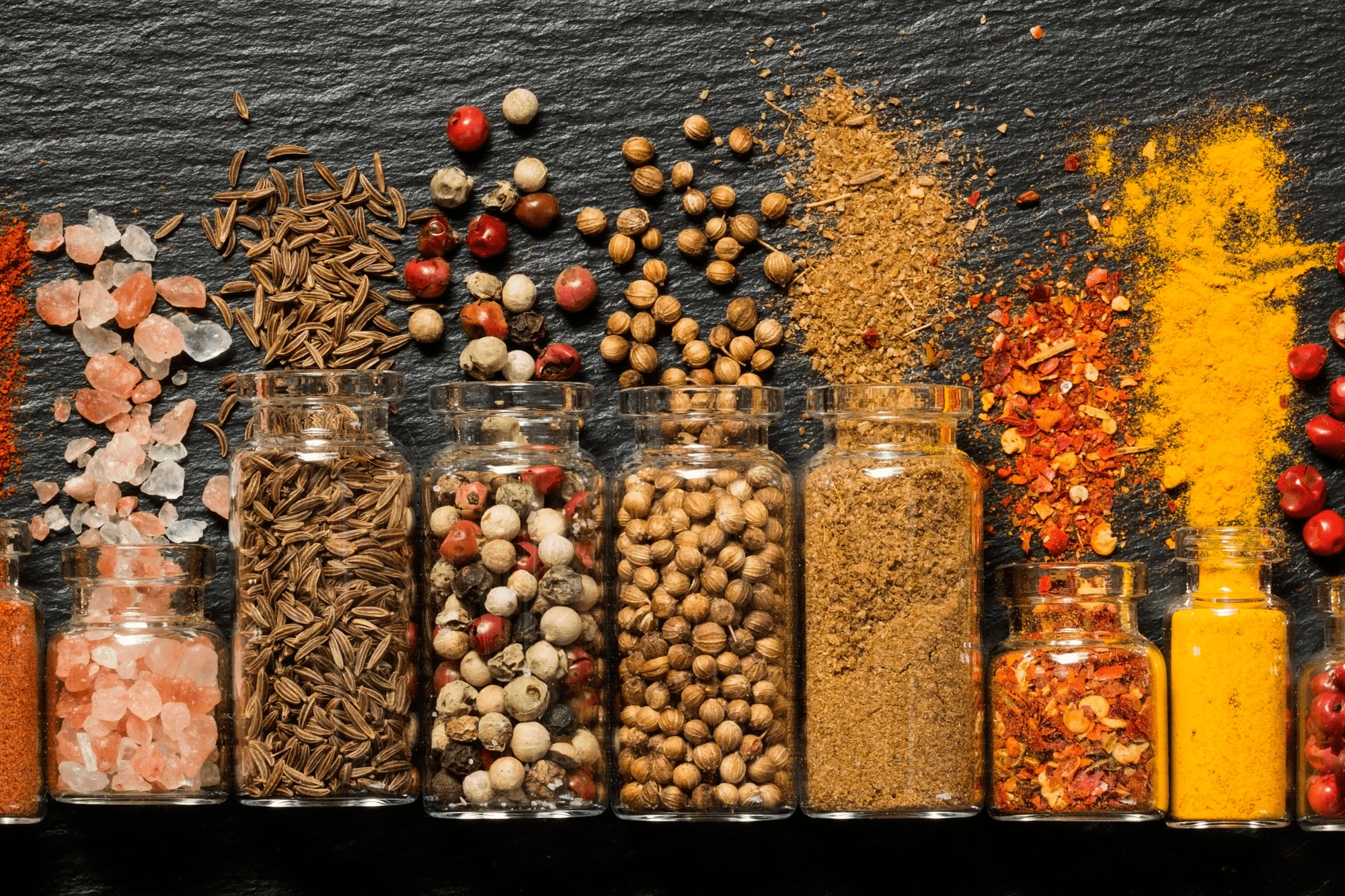 Die Welt der Gewürze Eine Gruppe von Glasgefäßen mit verschiedenen Gewürzen.