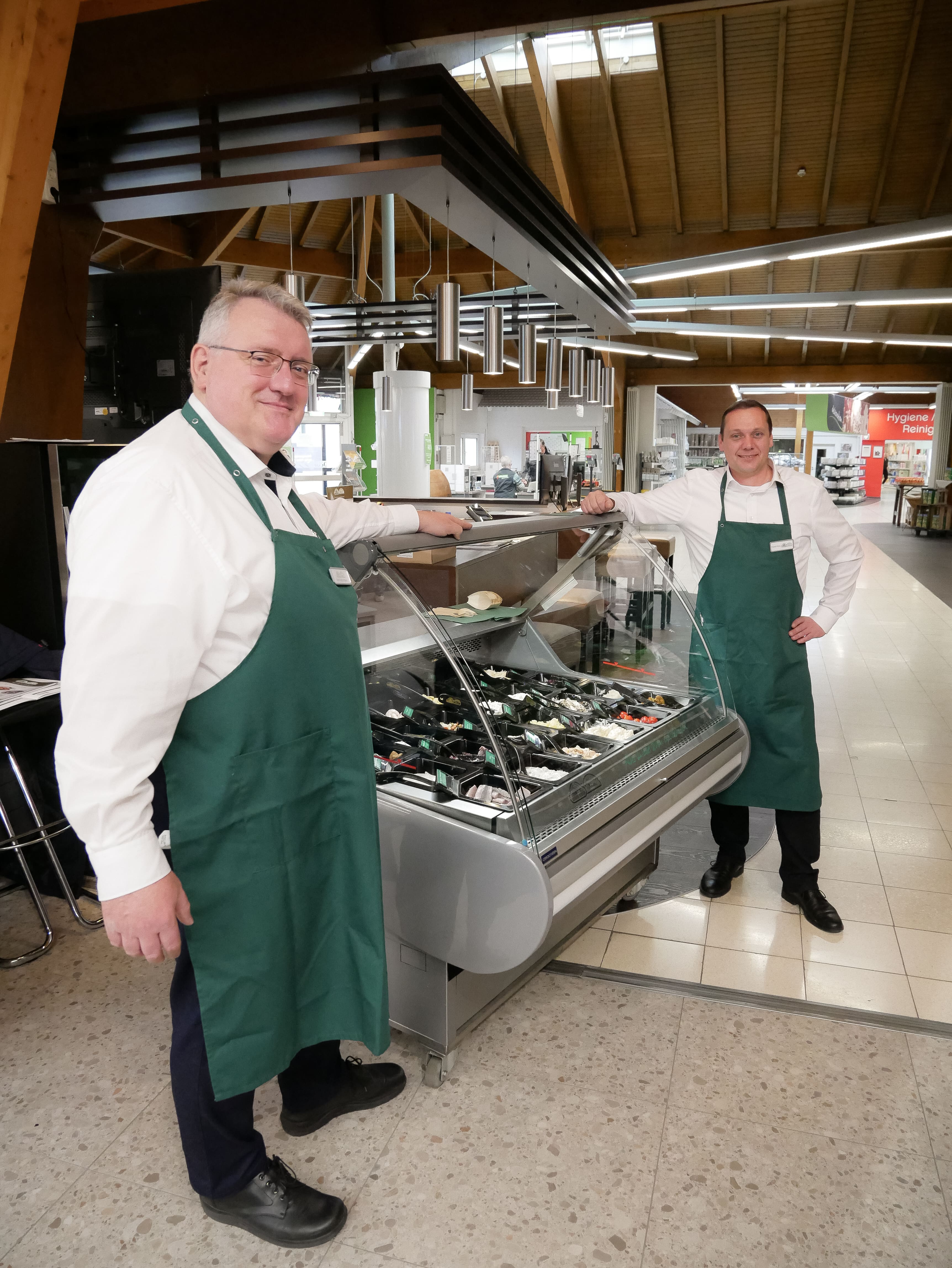 Zwei Männer stehen neben einer Vitrine.